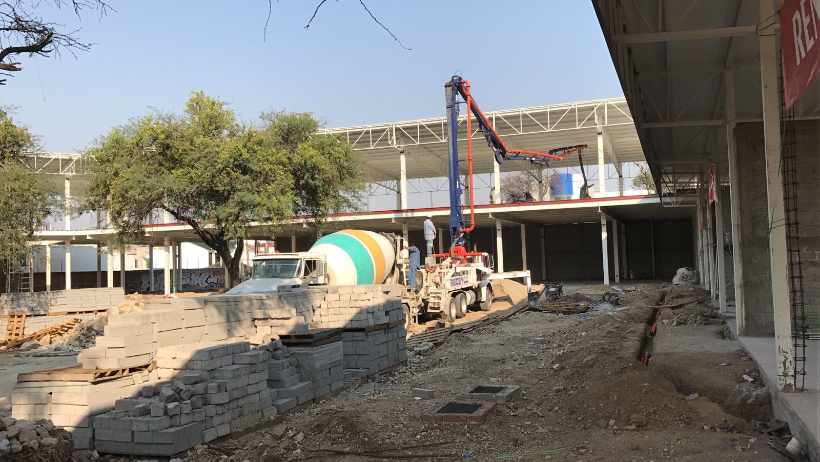 Planta baja de Europlaza con locales comerciales iluminados en noche, proyecto comercial Fer Et Ciment Guanajuato